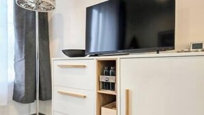 Une cuisine moderne dotée d’un téléviseur à écran plat, de tiroirs en bois et d’une étagère intégrée.