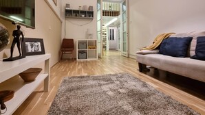 A living room with a sofa, a rug, a television, a framed picture, a small table, and a bookshelf. - MidTerm - Pody Apartment Budapest (Budapest)