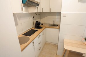 A compact kitchen with a sink, a coffee maker, and a small countertop.