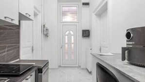 A modern kitchen with a central island, a built-in oven, and a microwave. - IMCT - Dizsu's Place Budapest (Budapest)