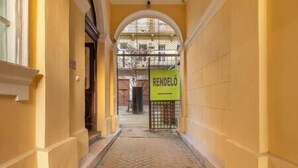 A corridor with a tiled floor and a yellow wall. There is a sign with the word "RENDELO" on it. - IMCT - Dizsu's Place Budapest (Budapest)