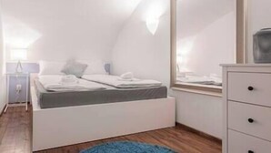 A modern bedroom with a bed, a dresser, and a large mirror. - IMCT - Beautiful Home at Basilica 1 (Budapest)