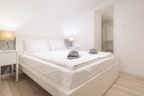 Une chambre à coucher moderne, avec un lit, des tables de chevet et une armoire.
