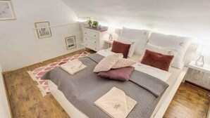 Een slaapkamer met een bed, nachtkastjes en een dressoir.