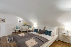 Une chambre à coucher avec un lit, des tables de chevet, un bureau et une chaise.