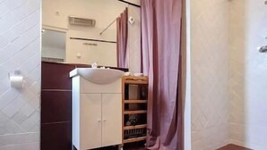 A bathroom with a white sink, a mirror, and a wooden shelf. - IMCT - Astoria Apartment Budapest (Budapest)