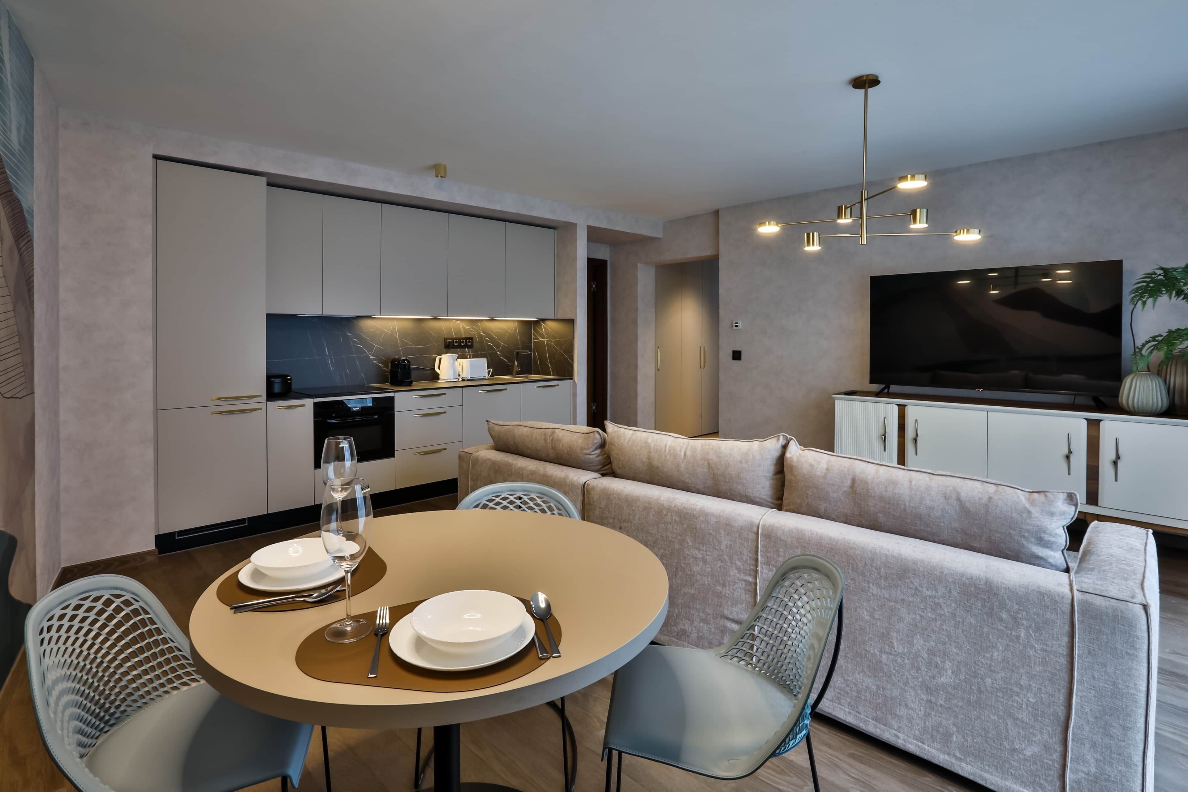 Een moderne woonruimte met een eethoek, keuken en een entertainmentinstallatie.