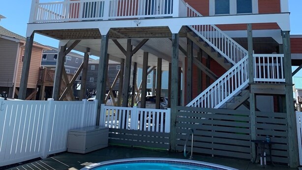 A two-story building with a balcony and a pool.