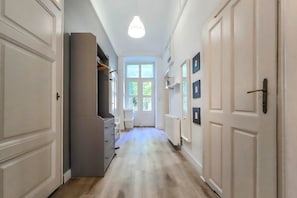 A hallway with a radiator, a light fixture, and a door with a handle. - IMCT - Seventh Sense Apartment (Budapest)