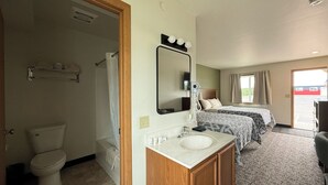 Een hotelkamer met een badkamer, een wastafel en twee bedden.
