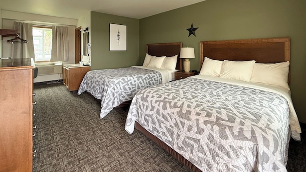 Een hotelkamer met twee bedden, een bureau, een stoel, een dressoir, een raam met gordijnen, een ster decoratie aan de muur en een ingelijst schilderij.