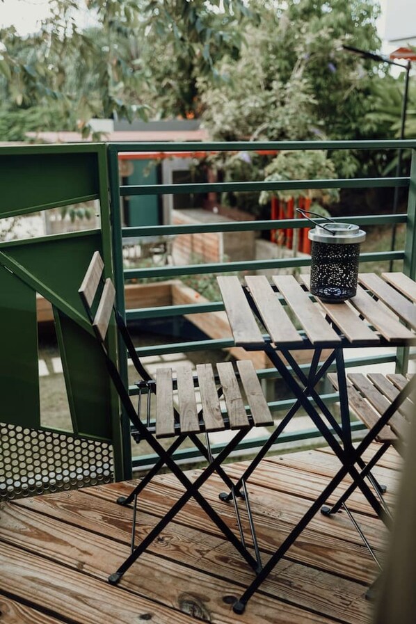 Eine Holzterrasse mit Metallgeländer und einem Tisch mit Kerzenhalter.