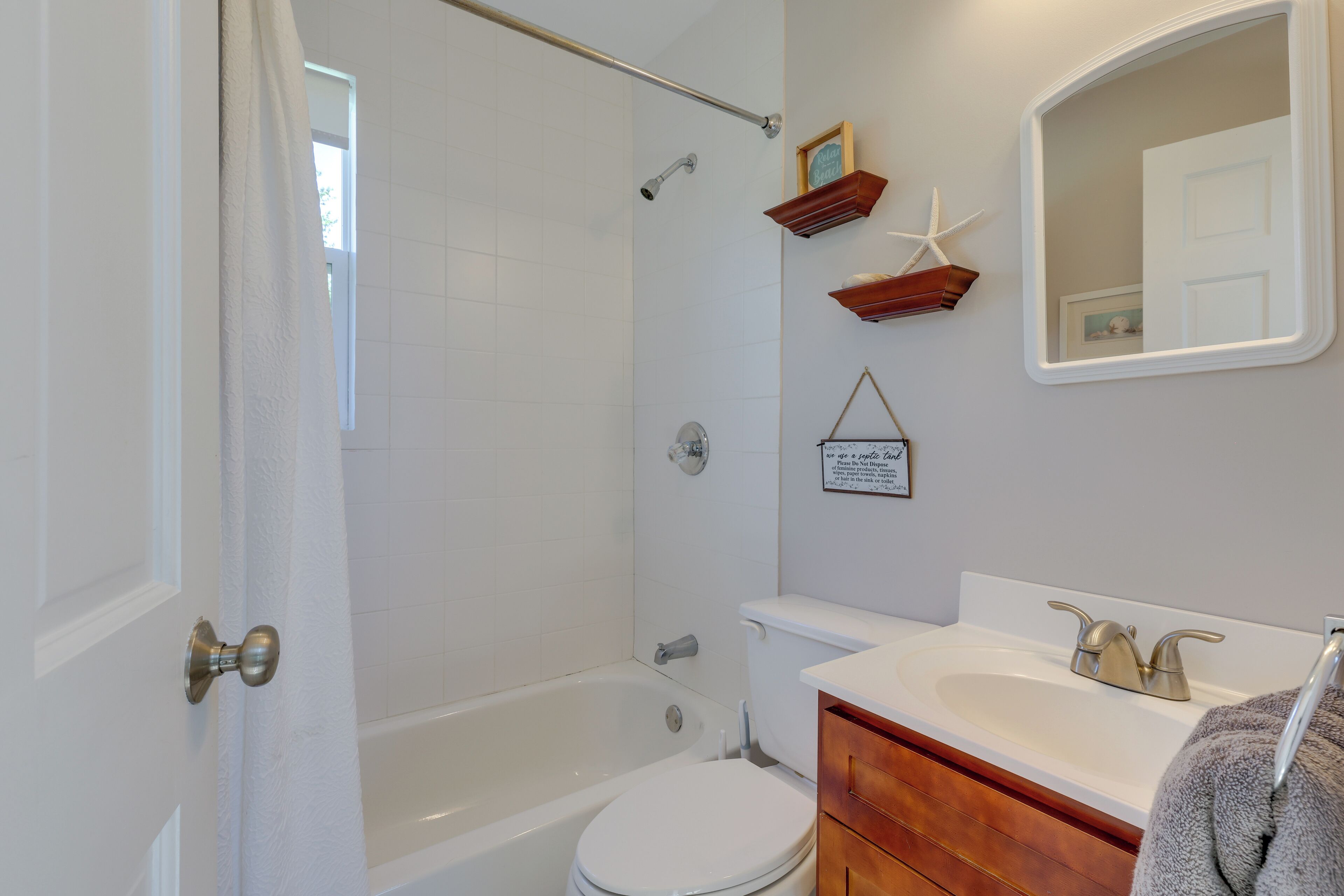 Une salle de bain équipée d’une baignoire, de toilettes, d’un lavabo et d’un miroir.