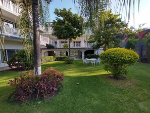 A courtyard with a seating area, a brick wall, and a tree. - Villa Salvatore (Xochitepec)