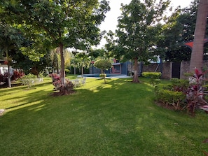 A well-maintained garden with a swimming pool, surrounded by trees and shrubs. - Villa Salvatore (Xochitepec)