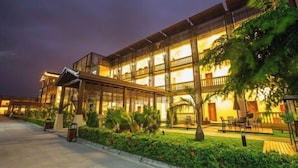A multi-story hotel with outdoor seating areas and a well-lit facade. - Longxing Lehman Sea View Resort (Sanya)