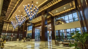 A spacious lobby with a high ceiling, large windows, and a central chandelier. - Longxing Lehman Sea View Resort (Sanya)