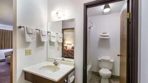 Et badeværelse med håndvask, spejl og toilet.