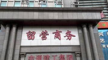Fachada de edificio con señalización que indica un centro de negocios y una obra en construcción.