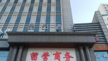 A building with a sign that reads '留营商务' (Liuye Commerce) and '精品酒店' (Premium Hotel).