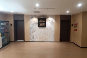 A hotel lobby with a marble wall, a reception desk, and a vending machine. - jing' pinCloud Series-Shijiazhuang Xinhua West Road 54 Suobai·Cloud Hotel (Shijiazhuang)