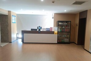 A reception desk with a computer, a beverage refrigerator, and a wall-mounted information board. - jing' pinCloud Series-Shijiazhuang Xinhua West Road 54 Suobai·Cloud Hotel (Shijiazhuang)