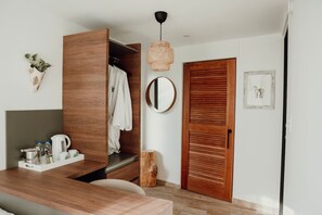 A modern room with a wooden wardrobe, a round mirror, a wooden door, and a small wooden stool.