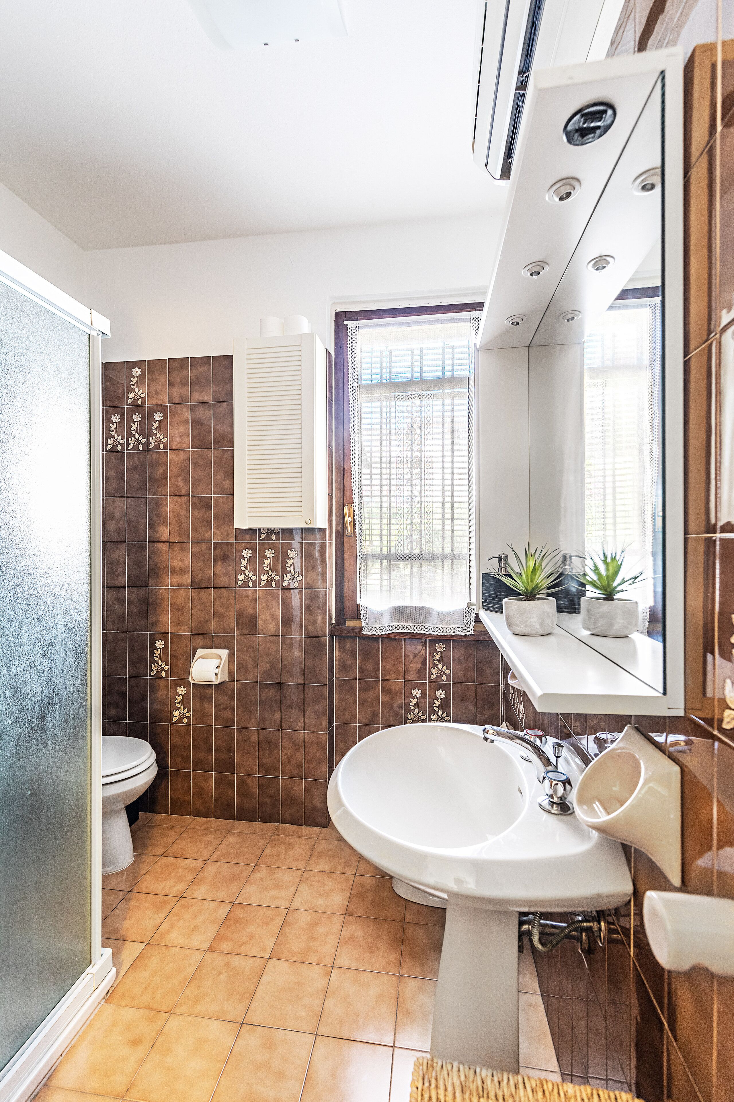 Ein Badezimmer mit Toilette, Waschbecken und Spiegel.