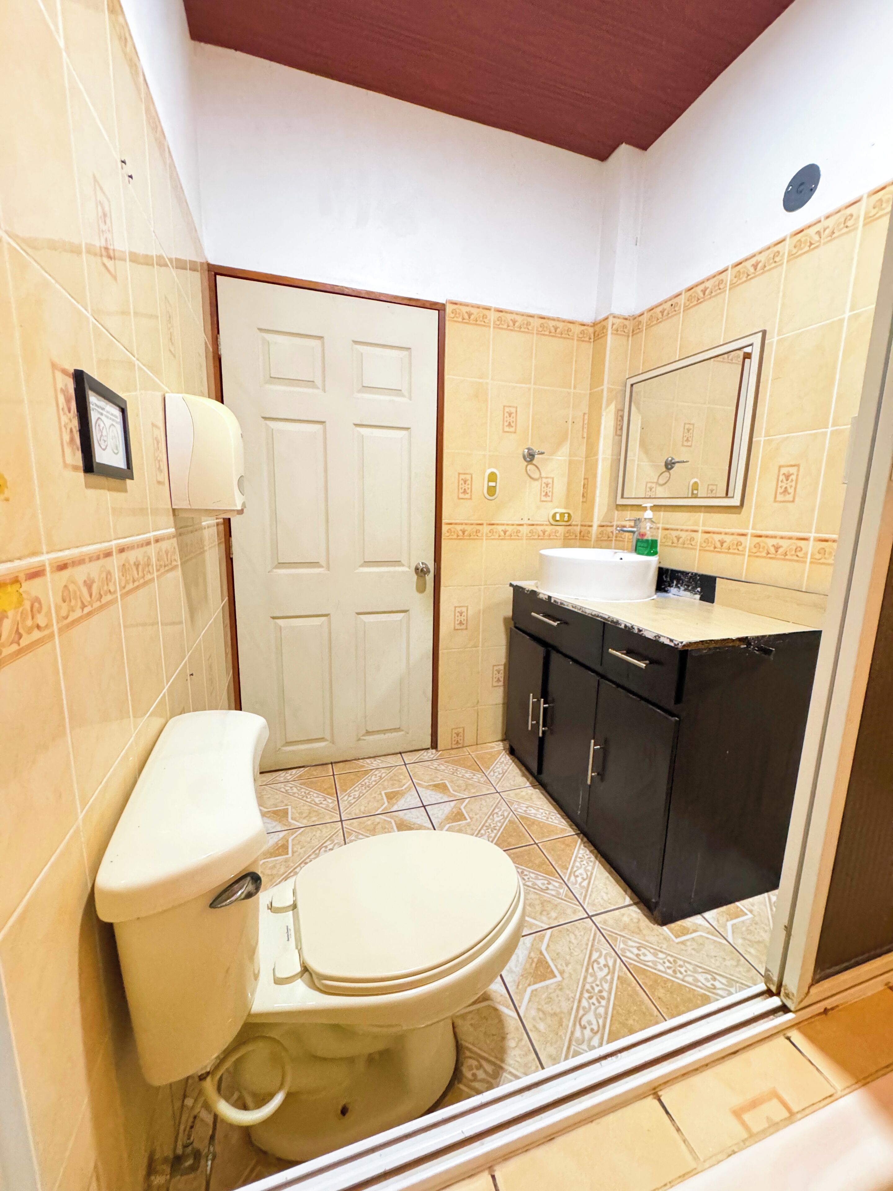 Une salle de bain avec des toilettes, un lavabo et un meuble de rangement.