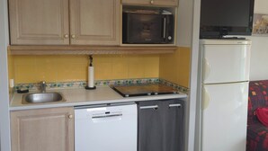 A compact kitchen with a microwave, stove, and refrigerator. - Les rives des Issambres 1201 (Roquebrune-sur-Argens)