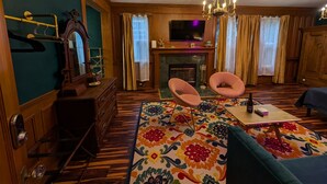 A traditional living room with a fireplace, a television, and a patterned rug. - Spacious King Suite! Cher inspired unit. (Sturgeon  Bay)