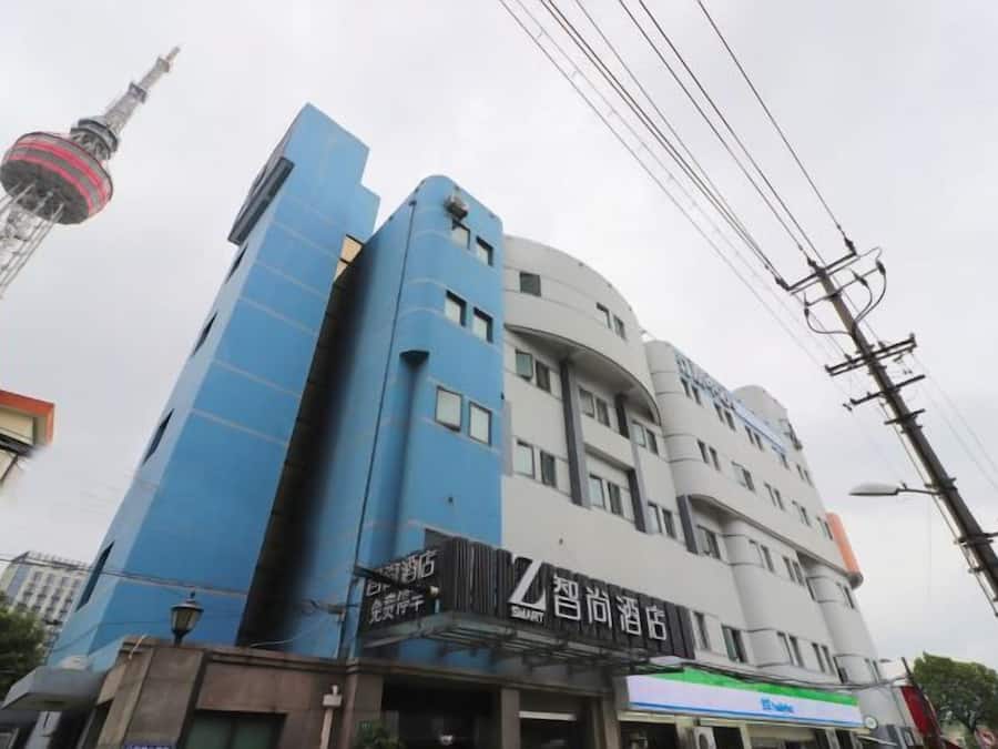 A multi-story building with a prominent blue facade and a curved white section.