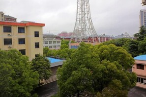 A cityscape with a prominent tower, buildings, and lush green trees.