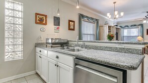 A kitchen with white cabinets, granite countertops, stainless steel appliances, and a window with decorative glass panels. - South Padre Island: Pool Access, 1 Block to Beach! (South Padre Island)