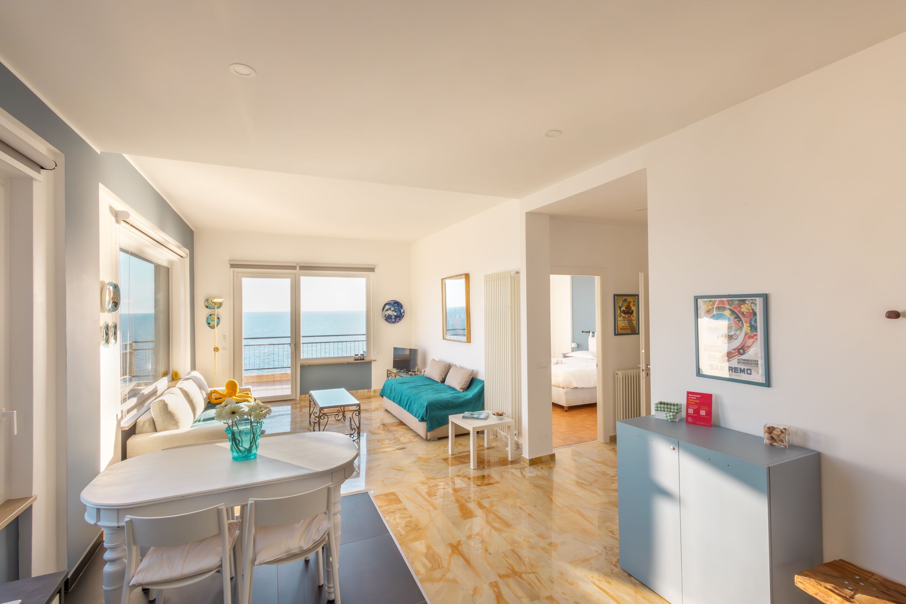 Un vaste espace de vie comprenant une table à manger, un canapé et une vue sur la mer.