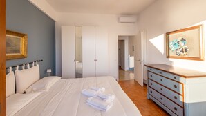 A bedroom with a bed, a dresser, a mirror, and a framed picture on the wall. - Sky & Sea Apartment by Wonderful Italy (Ospedaletti)