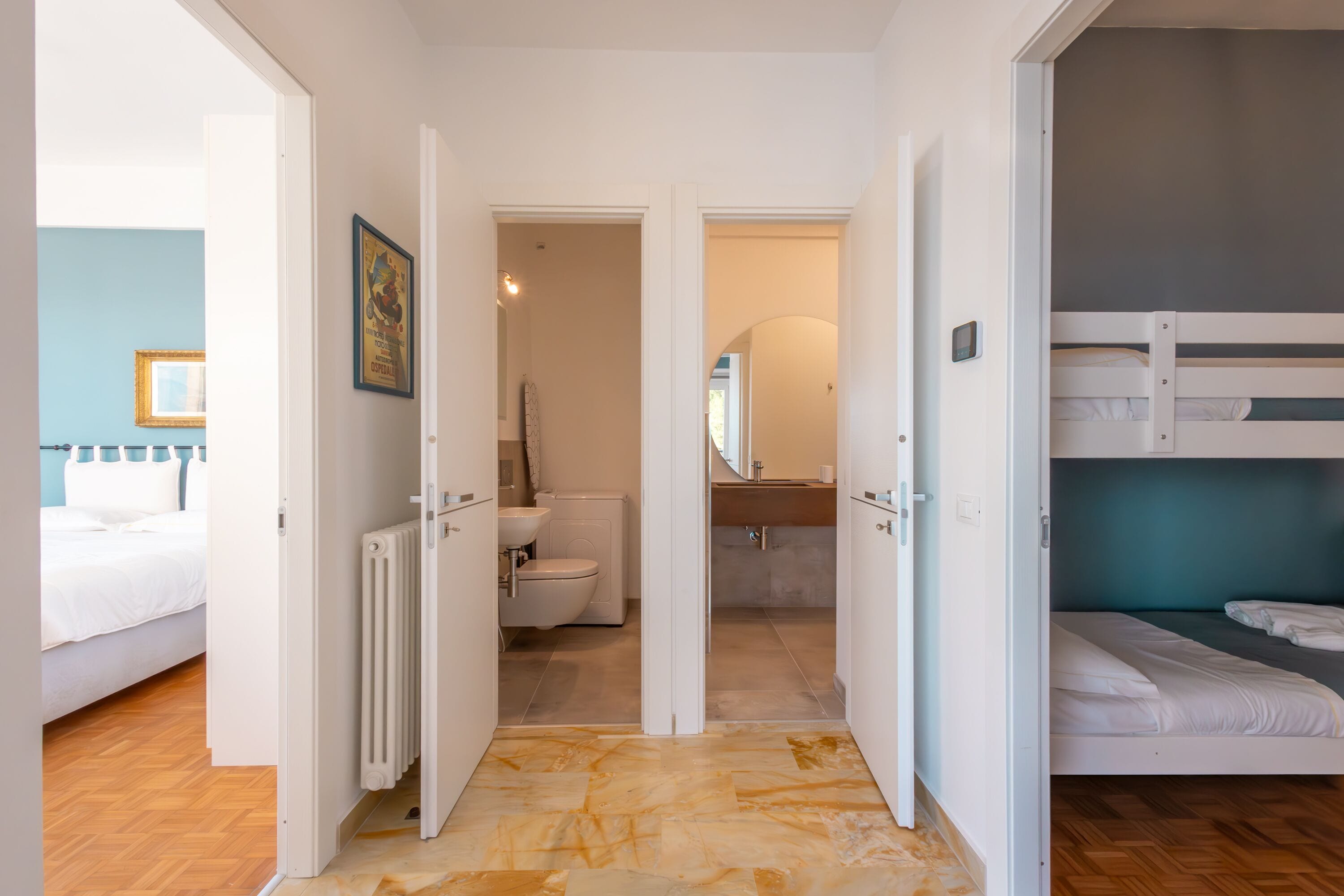 Ein Zimmer mit einem Bett, einem Heizkörper, einem Badezimmer mit Toilette und Waschbecken sowie einem Etagenbett.
