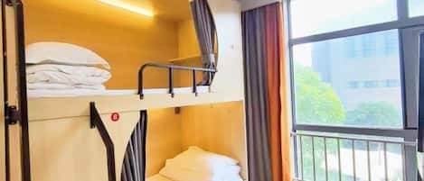 A bunk bed room with a window and curtains.