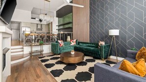 A modern living room with a green sofa, a round coffee table, and a grey sofa. - Centennial Quarters: Holiday House near Vandy! (Nashville)