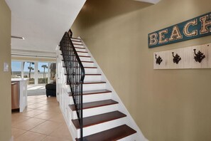 Una escalera con barandal negro que conduce a un rellano.