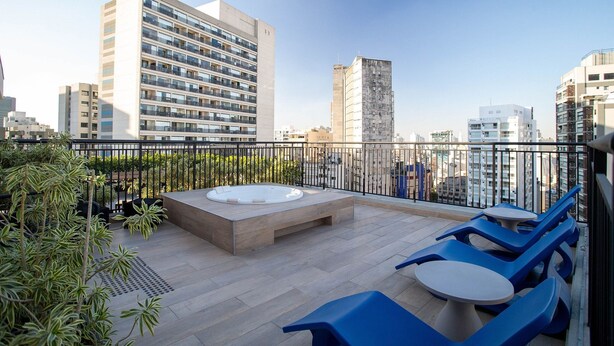 A rooftop terrace with a hot tub, seating area, and city views. - My One Bela Vista  (São Paulo)
