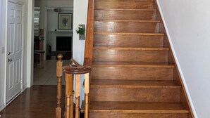 A wooden staircase with a handrail, leading to an upper floor. - Executive End Unit Townhome (Milton)