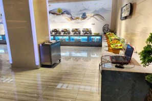 Un espace d’accueil avec un comptoir, un ordinateur portable et un coin café.