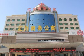 Un edificio con una cúpula azul grande y señalización que indica 'HuiLi Business Hotel'.