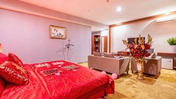 Una habitación de hotel con una cama grande, un escritorio, una silla y un florero con flores.