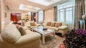 Ein modernes Wohnzimmer mit einer Sofagarnitur, einem Couchtisch und einer Zimmerpflanze.