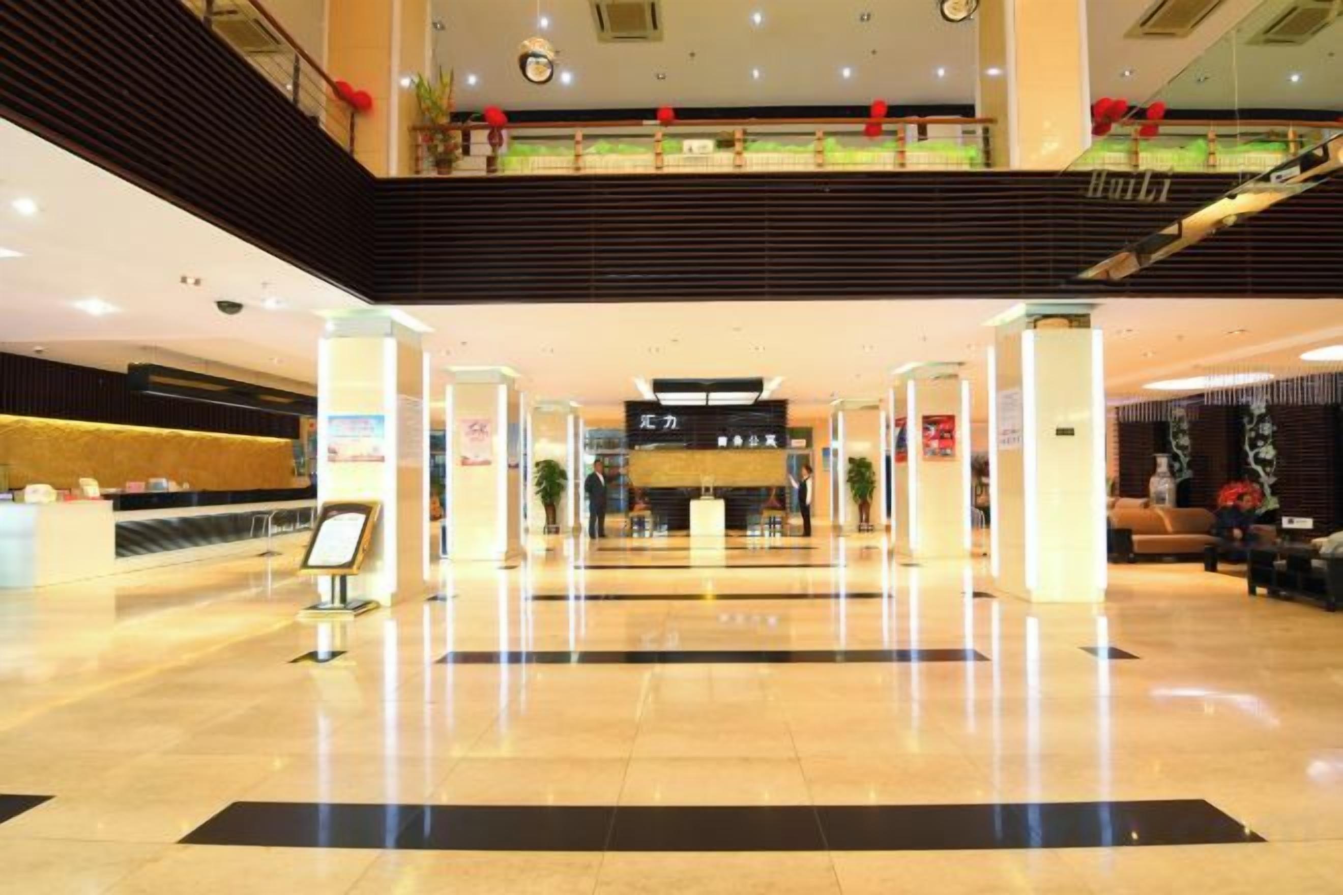 A hotel lobby with a reception desk, a staircase, and a check-in counter.