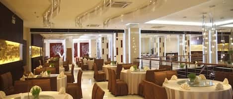 A modern dining area with round tables, brown upholstered chairs, and a central walkway.