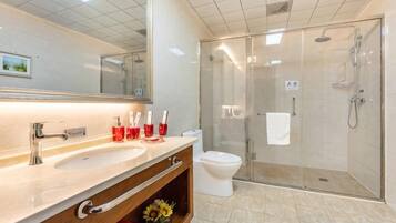 A modern bathroom with a glass shower enclosure, a white sink, and a large mirror.
