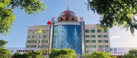 Un edificio de varios pisos con una cúpula central y fachada de vidrio moderna.